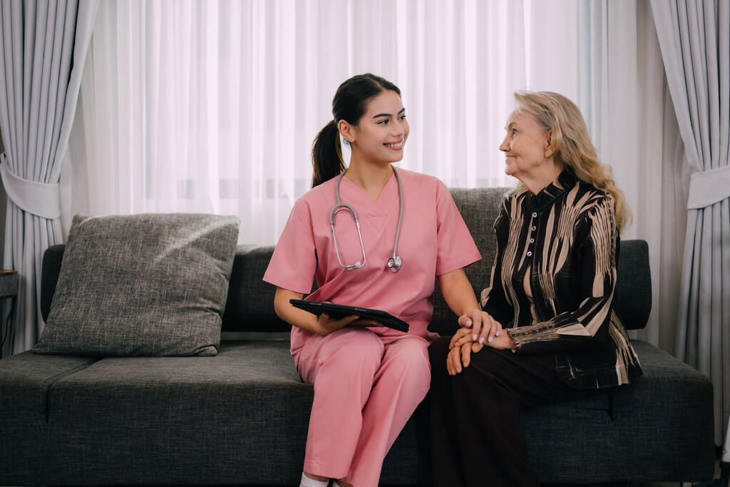 young doctor or nurse visiting happy senior patient at home